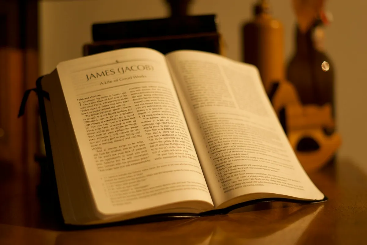 An open Bible on a wooden table in soft morning light